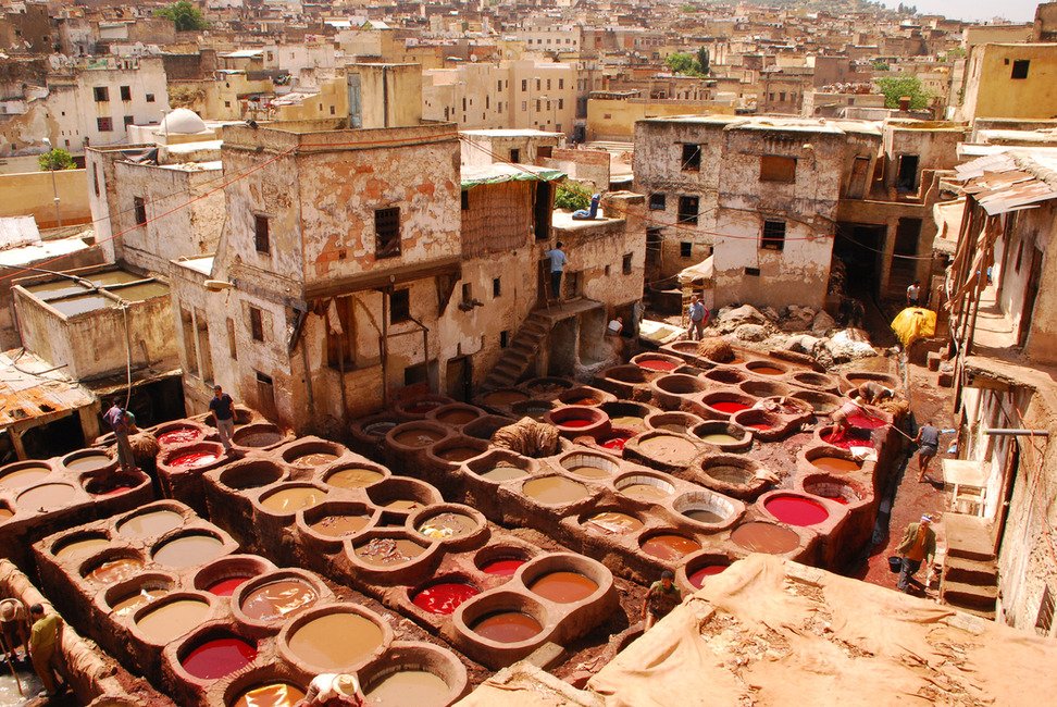Circular leather dye vats surrounded by old workshop buildings in the medina of Fes, Morocco